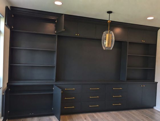 Custom black built-in media wall with brass pulls and open shelving, Savannah GA